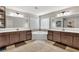 A luxurious bathroom featuring dual vanities, dark wood cabinets, and a corner soaking tub at 3890 Pleasant Woods Dr, Cumming, GA 30028