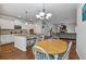Open-concept kitchen with an eat-in island overlooking the dining area and living room at 3890 Pleasant Woods Dr, Cumming, GA 30028