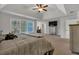 Spacious main bedroom featuring tray ceilings, a ceiling fan, and a large window providing ample natural light at 3890 Pleasant Woods Dr, Cumming, GA 30028