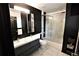 Modern bathroom with dual sinks, dark walls, and glass-enclosed shower at 657 S Grand Nw Ave, Atlanta, GA 30318