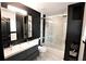 Modern bathroom featuring dual sinks, sleek black walls, and a glass-enclosed shower at 657 S Grand Nw Ave, Atlanta, GA 30318