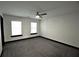 Large bedroom with plush carpet, a ceiling fan, and two windows at 657 S Grand Nw Ave, Atlanta, GA 30318