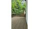 Side view of wood deck with a metal railing surrounded by trees and greenery at 657 S Grand Nw Ave, Atlanta, GA 30318