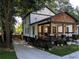 Beautiful home featuring a covered porch, black framed windows, a private driveway, and curb appeal with colorful landscaping at 657 S Grand Nw Ave, Atlanta, GA 30318