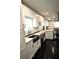A bright, modern kitchen featuring white cabinets, stainless steel appliances, and dark hardwood flooring at 657 S Grand Nw Ave, Atlanta, GA 30318