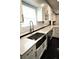 Close-up of a modern kitchen sink with white cabinets, countertops, and stainless steel appliances at 657 S Grand Nw Ave, Atlanta, GA 30318