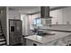 Bright kitchen with white cabinets, stainless steel appliances, and a large island with seating at 657 S Grand Nw Ave, Atlanta, GA 30318