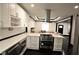 Modern kitchen with white cabinets, stainless steel appliances, and a view into the living room at 657 S Grand Nw Ave, Atlanta, GA 30318