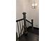 Staircase with wooden steps, black metal railing, and a modern light fixture at 657 S Grand Nw Ave, Atlanta, GA 30318