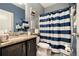Bathroom featuring a vanity with granite counters and blue and white striped shower curtain at 10 Tabor Trce, Oxford, GA 30054