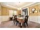 Dining room features wainscoting, a chandelier, and an elegant table setting at 10 Tabor Trce, Oxford, GA 30054