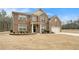Charming two-story brick home featuring a manicured lawn and attached two-car garage at 10 Tabor Trce, Oxford, GA 30054