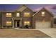 Charming two-story brick home featuring a manicured lawn and attached two-car garage at 10 Tabor Trce, Oxford, GA 30054