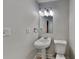 Cozy half bath features pedestal sink, a mirror, and a toilet at 805 Kilkenny Cir, Lithonia, GA 30058