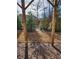 View of a wooded backyard with a wooden privacy fence and a pergola structure at 3765 Davis Cir, Duluth, GA 30096