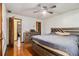 Bright bedroom featuring a ceiling fan, wood floors, and a large bed frame at 2169 Tiffany Ln, Lithonia, GA 30058