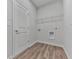 Practical laundry room featuring laminate flooring and storage shelves at 3614 Arrow Root Cir, Loganville, GA 30052