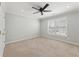 This bright bedroom features carpet, a ceiling fan, and a window with white shutters at 1414 Lynchburg Trce, Grayson, GA 30017