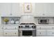 Close-up of a stainless steel oven and cooktop with light cabinets and marble backsplash at 2525 Peachtree Ne Rd # 25, Atlanta, GA 30305