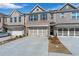 Brick townhomes showing attached two-car garages and a long driveway at 2989 Chene Pl, Duluth, GA 30097