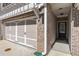 A brick townhome featuring an attached two-car garage and a covered entrance at 2989 Chene Pl, Duluth, GA 30097