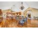Expansive kitchen features a large island, vaulted ceilings, stainless appliances, and elegant chandeliers over a dining table at 4001 Pool Rd, Winston, GA 30187