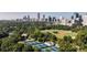 An aerial view of tennis courts within a city park, with the city skyline in the background at 1101 Juniper Ne St # 721, Atlanta, GA 30309