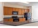 Functional kitchen featuring wood cabinetry, solid surface counters, and black appliances at 1830 Bayrose Cir # 30B, East Point, GA 30344