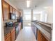 Galley kitchen with dark appliances, wood cabinets, and tile flooring at 1830 Bayrose Cir # 30B, East Point, GA 30344