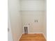 A simple laundry room with connections, shelving and durable wood look flooring at 1830 Bayrose Cir # 30B, East Point, GA 30344