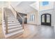 Grand foyer with staircase, hardwood floors, ornate black double doors, and soaring ceilings at 3825 Hall Rd, Dacula, GA 30019
