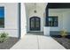 Arched black double front door with decorative ironwork and a charming light fixture at 3825 Hall Rd, Dacula, GA 30019