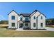 Stunning white brick home featuring black trim, a manicured lawn, and professional landscaping at 3825 Hall Rd, Dacula, GA 30019