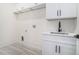 Well-lit laundry room with white cabinetry, countertop, and a modern black faucet at 3825 Hall Rd, Dacula, GA 30019