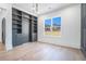 Bright home office featuring custom built-in shelving, light hardwood floors, and a scenic outdoor view at 3825 Hall Rd, Dacula, GA 30019