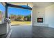 Covered outdoor kitchen has a stainless steel grill, countertop, and a cozy fireplace at 3825 Hall Rd, Dacula, GA 30019