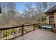 This spacious back deck with wood railing looks out over the backyard, with a pool and green trees in the distance at 829 Waterford Estates Mnr, Canton, GA 30115