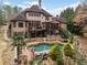 A spacious backyard boasts an in-ground pool, deck, outdoor kitchen, and mature landscaping at 829 Waterford Estates Mnr, Canton, GA 30115