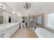 Luxurious bathroom with double vanity, soaking tub, glass shower, and an elegant chandelier at 829 Waterford Estates Mnr, Canton, GA 30115