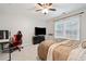 This bedroom features carpet, ceiling fan, desk and bed, and large windows for natural light at 829 Waterford Estates Mnr, Canton, GA 30115