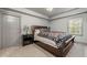 This bedroom features carpet, ceiling fan, bedside table with lamp, and large windows for natural light at 829 Waterford Estates Mnr, Canton, GA 30115