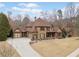 An exterior elevation showcases a large house with a three car garage, a long driveway and a well kept lawn at 829 Waterford Estates Mnr, Canton, GA 30115