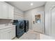 Laundry room with sink, cabinetry, and modern washer and dryer units at 829 Waterford Estates Mnr, Canton, GA 30115