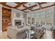 Inviting living room featuring coffered ceilings, stone fireplace, and expansive windows offering scenic views of the surrounding landscape at 829 Waterford Estates Mnr, Canton, GA 30115
