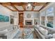 Beautiful living room featuring coffered ceilings, a stone fireplace, and large windows offering scenic views of the surrounding landscape at 829 Waterford Estates Mnr, Canton, GA 30115