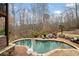 An inground pool has a basketball hoop and overlooks a wooded lot at 829 Waterford Estates Mnr, Canton, GA 30115