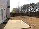 View of the backyard, including the concrete patio and the edge of a wooden perimeter fence at 158 Weatherstone Dr, Woodstock, GA 30188
