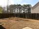 Spacious backyard featuring a wooden fence and minimal vegetation at 158 Weatherstone Dr, Woodstock, GA 30188