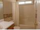 Bright bathroom featuring a tub with shower, decorative wallpaper, and ample counter space at 158 Weatherstone Dr, Woodstock, GA 30188