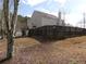 Exterior rear view of a beige home surrounded by a dark wood perimeter fence at 158 Weatherstone Dr, Woodstock, GA 30188